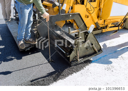 Steam roller an asphalt paver machine are used during construction new road as part of layering process Steam roller an asphalt paver machine are used during construction new road as part of layering process 101396653