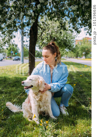 Young beautiful woman and her golden retriever dog having fun in spring Young beautiful woman and her golden retriever dog having fun in spring 101396686