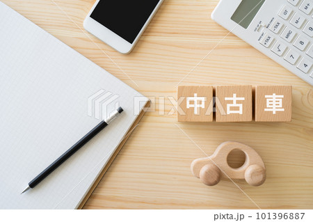 中古車と書かれたブロック、車のおもちゃ、電卓、スマホ、ノート、ペン 101396887
