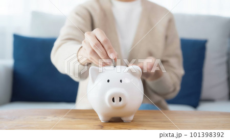 Asian woman putting coin in piggy bank. Save money and investment concept Asian woman putting coin in piggy bank. Save money and investment concept 101398392