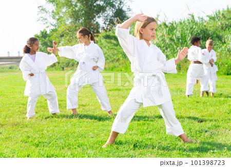 Little girl make karate exercises in park Little girl make karate exercises in park 101398723