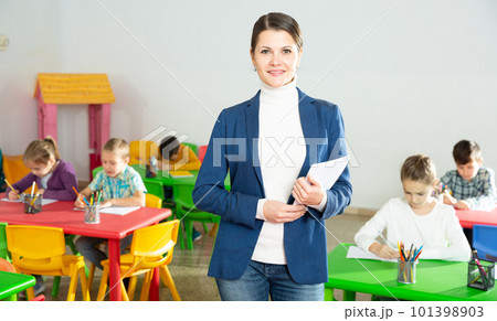 Portrait of friendly female teacher standing in classroom Portrait of friendly female teacher standing in classroom 101398903