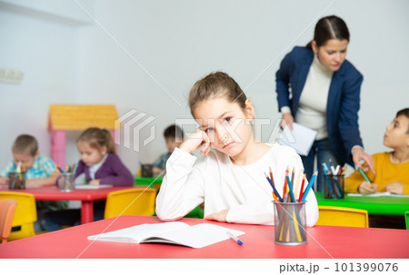 Tired schoolgirl at pupils desk at lesson Tired schoolgirl at pupils desk at lesson 101399076