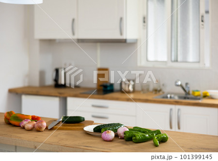 Cutting board with knife and vegetables in the kitchen Cutting board with knife and vegetables in the kitchen 101399145