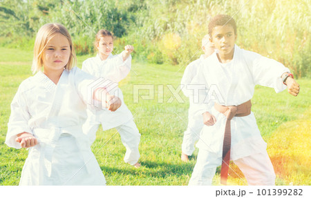 Positive children practicing karate in park Positive children practicing karate in park 101399282