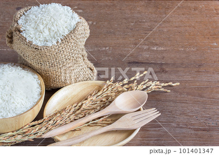 Jasmine rice in bowl and sack on old wooden table 101401347