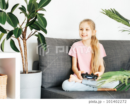 Girl playing video game at home 101402272