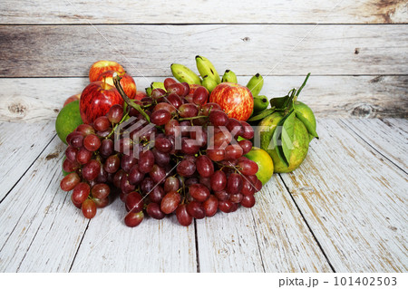 Various of fruits with Red grape, red apple and green orange on wooden background 101402503