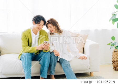 一緒にスマホを見る若い夫婦（カップル） 101405219