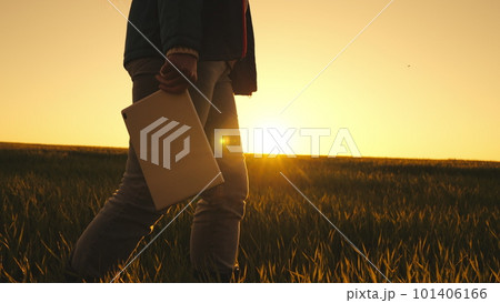 Agriculture. farmer rubber boots walks through green field wheat sunset. farmer work silhouette with digital tablet. smart farm. farmer feet walk boots across field. farming sunset. nature summer 101406166