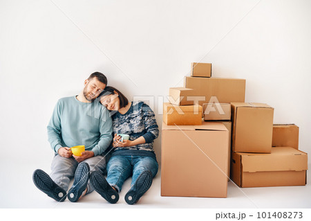 Happy carefree couple having break during moving to new house and relaxing on the floor enjoy their apartment 101408273