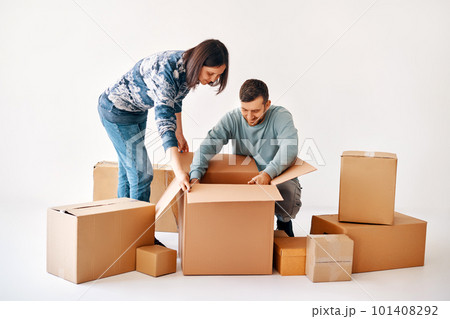 Happy couple unpacking boxes in new apartment at moving day 101408292