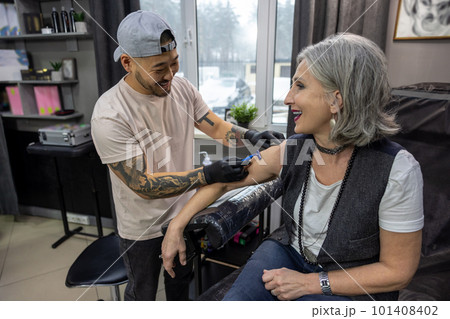 Tattoo master preparing client for a tattoo session 101408402