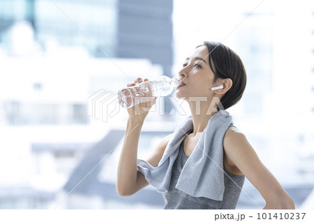 トレーニングの後休憩する女性 水分補給 ワークアウト トレーニングの後休憩する女性 水分補給 ワークアウト 101410237