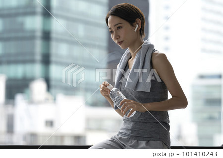 トレーニングの後休憩する女性 水分補給 ワークアウト トレーニングの後休憩する女性 水分補給 ワークアウト 101410243