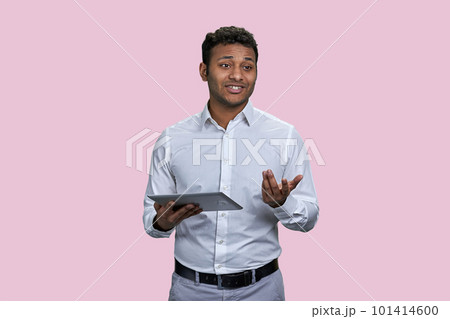 Young southeast asian man giving a speech using tablet pc. Isolated on pink background. 101414600