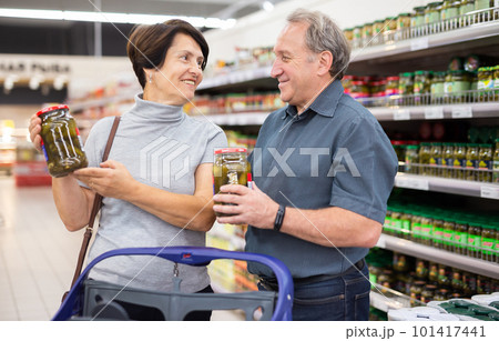 elderly couple choosing a jar of canned cucumbers elderly couple choosing a jar of canned cucumbers 101417441