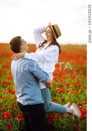 Loving couple walking on the poppy field. Enjoying time together. The concept of youth, love and lifestyle. 101418826