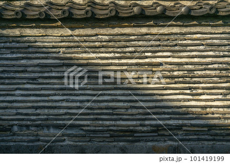 春の穏やかな日が当たる瓦が練りこんである築地塀・谷中・観音寺 101419199
