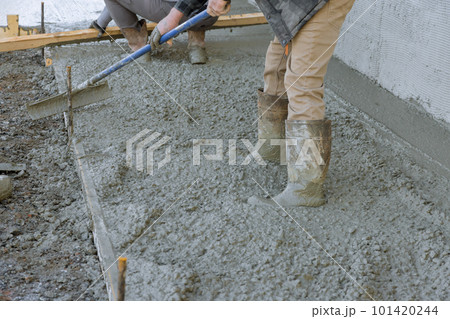 After pouring concrete employee used long trowels to level sidewalk. After pouring concrete employee used long trowels to level sidewalk. 101420244