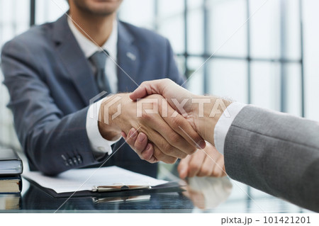 Portrait of confident mature specialist sitting at the table and reaching out his hand to the camera for a handshake 101421201