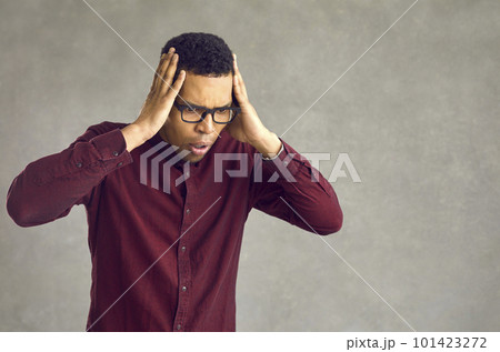 Shocked emotional african american man looking down toughing head studio shot 101423272