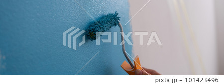 Male decorator painting wall in blue color Male decorator painting wall in blue color 101423496