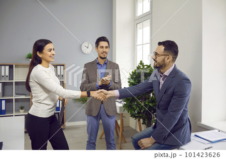 Young people meet in the office, make a business deal, smile and exchange handshakes 101423626