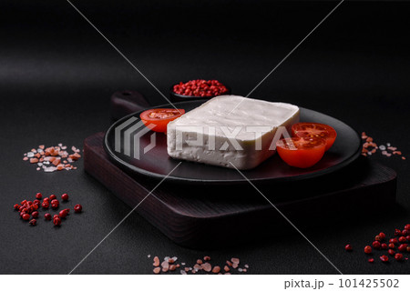 Delicious fresh rectangular shaped feta cheese with spices and vegetables 101425502
