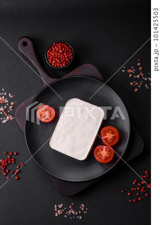 Delicious fresh rectangular shaped feta cheese with spices and vegetables 101425503