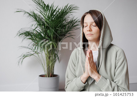 yoga and meditation, young woman with closed eyes and hands in namaste 101425753