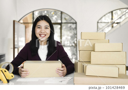 Female online business owner holding parcel and looking at camera. Female online business owner holding parcel and looking at camera. 101428469