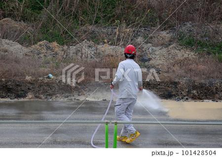 道路を水で洗う作業員 101428504