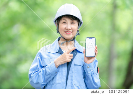 スマートフォンを持つ作業服の女性 スマートフォンを持つ作業服の女性 101429094