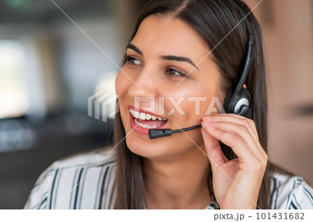 Young friendly operator woman agent with headsets working in a call centre. Young friendly operator woman agent with headsets working in a call centre. 101431682