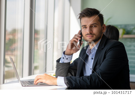 Young businessman talking on the phone at the office Young businessman talking on the phone at the office 101431717