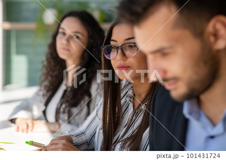 Creative business team sharing laptop in office, watching startup presentation, brainstorming, pointing at monitor, talking. 101431724