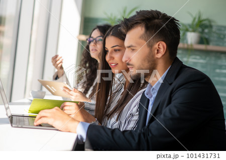 Creative business team sharing laptop in office, watching startup presentation, brainstorming, pointing at monitor, talking. Creative business team sharing laptop in office, watching startup presentation, brainstorming, pointing at monitor, talking. 101431731
