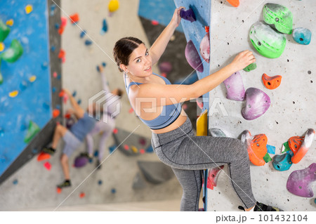 Young woman practicing rock climbing on climbing wall Young woman practicing rock climbing on climbing wall 101432104