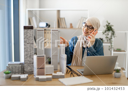 Woman talking on cell phone about design project at work Woman talking on cell phone about design project at work 101432453