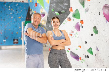 Adult man and young woman posing on climbing wall 101432481