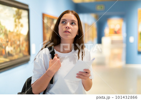Portrait of a young girl visitor on at the exhibition of paintings in the museum 101432866