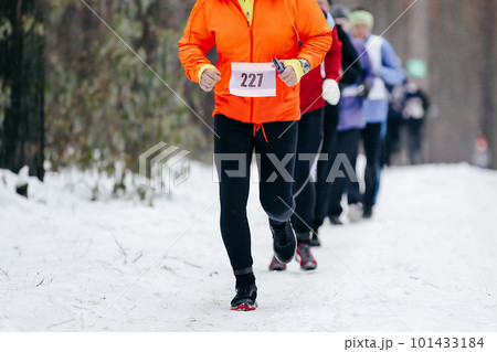 group runners athletes run winter trail marathon, people jogging together snowy forest 101433184