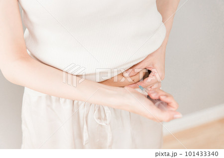 お腹をつまんでインスリン注射・ダイエット注射・不妊治療薬を注射する女性 101433340