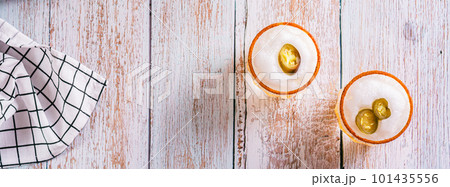 Alcoholic cocktail orange margarita with egg foam, jalapeno pepper and tajine top view web banner Alcoholic cocktail orange margarita with egg foam, jalapeno pepper and tajine top view web banner 101435556