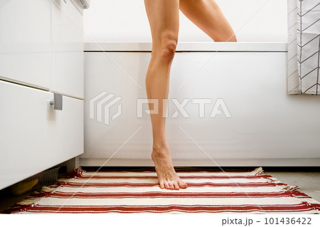 Unrecognizable woman coming out of bathtub 101436422