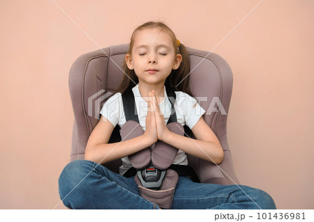 Funny happy caucasian girl of primary school age feels calm and safe in a car seat Funny happy caucasian girl of primary school age feels calm and safe in a car seat 101436981