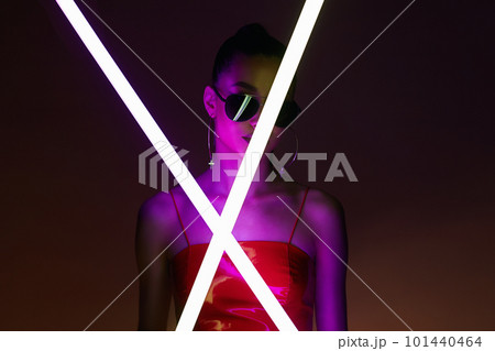 beautiful young woman with neon lamp. Pretty girl in sunglasses 101440464