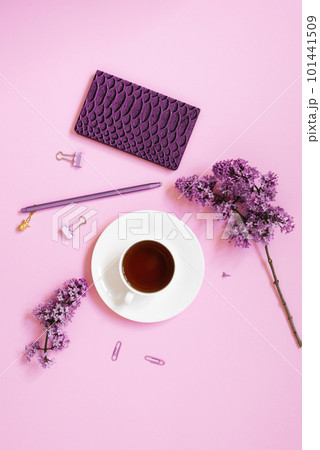 A cup of tea, notebooks, a pen, a bouquet of lilacs on a purple background. Purple spring flowers. Composition for a blogger. or business A cup of tea, notebooks, a pen, a bouquet of lilacs on a purple background. Purple spring flowers. Composition for a blogger. or business 101441509
