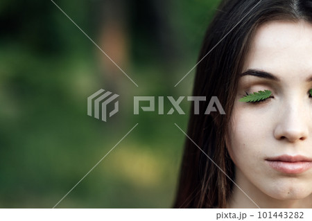Celebrate Earth Month, Earth Day. Spend time in nature. Connect to nature is way to mitigate climate anxiety. Young woman, girl outdoors portrait on green nature background 101443282